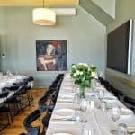 two long tables set at Estia Restaurant in the private dining area.